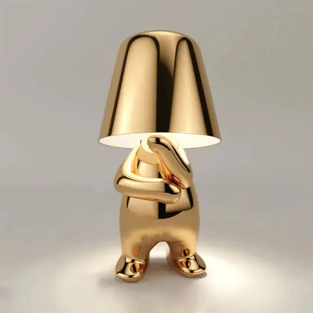 Gold Table lamp designed as a little man, offering a unique and decorative lighting solution.