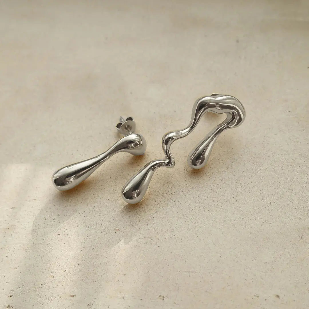 Asymmetrical liquid metal drop earrings, offering a unique and contemporary style.