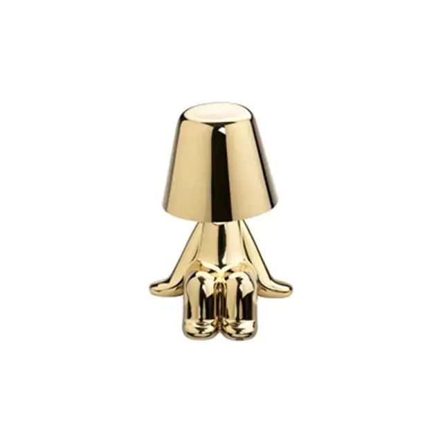 Gold LED table lamp featuring a charming little man design, adding personality to your decor.