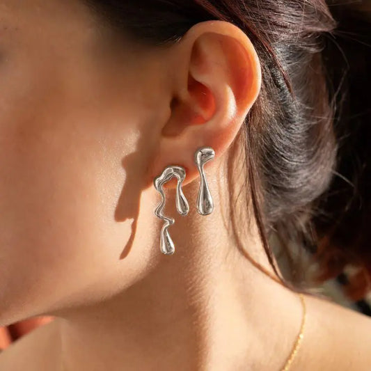 Asymmetrical liquid metal drop earrings, offering a unique and contemporary style.