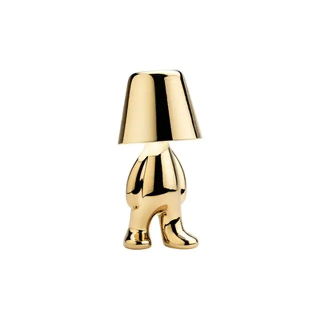 Gold LED table lamp in the shape of a miniature man, creating a cheerful atmosphere.